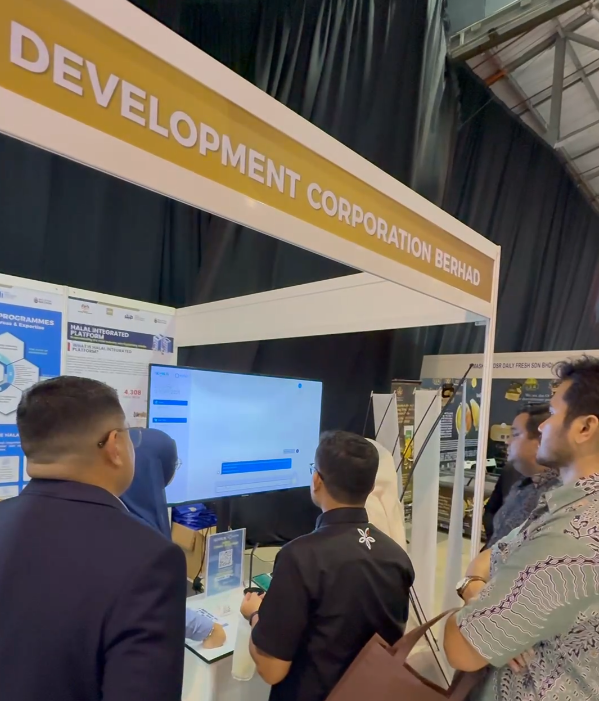 Trade show attendees gathered at the Go Halal booth, viewing a live technical demonstration of HaNa interface on a flat-screen display.